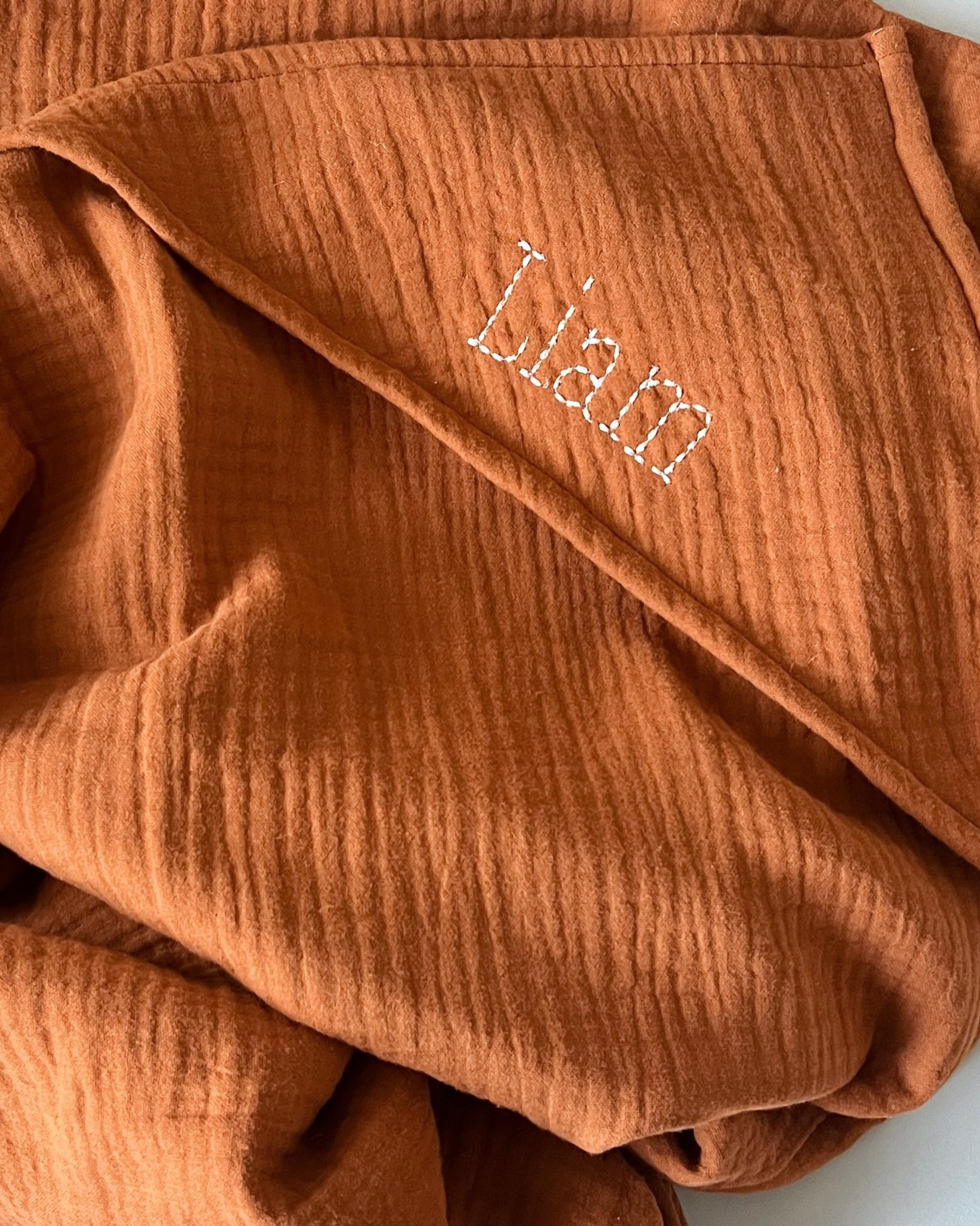 Geborduurde omslagdoek katoen hydrofiel cognac en handstitch lettertype